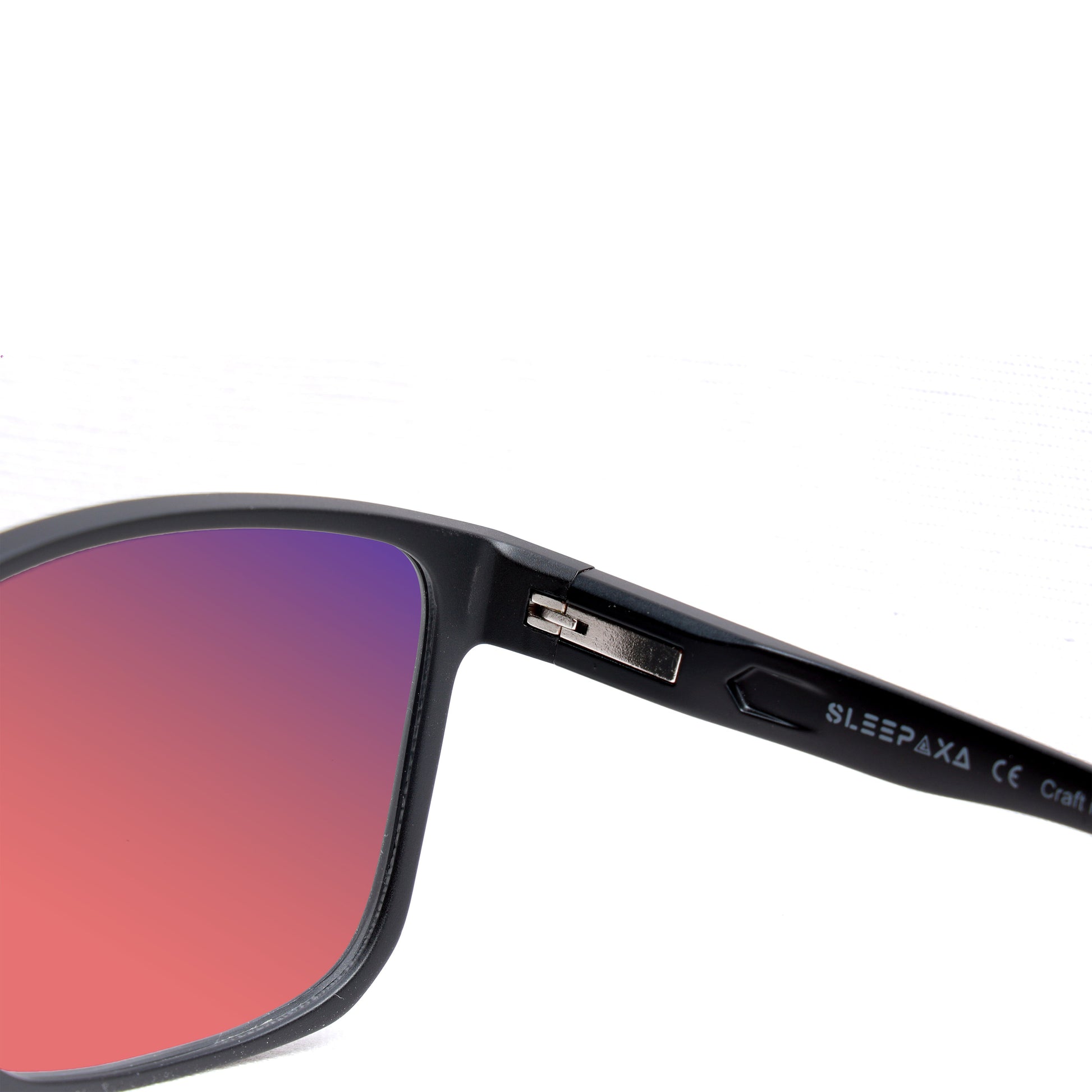 Close-up view of Sleepaxa fl41 glasses with black frame and rose-tinted lenses, featuring the Sleepaxa brand logo on the temple arm designed to reduce eye strain and alleviate migraine symptoms.